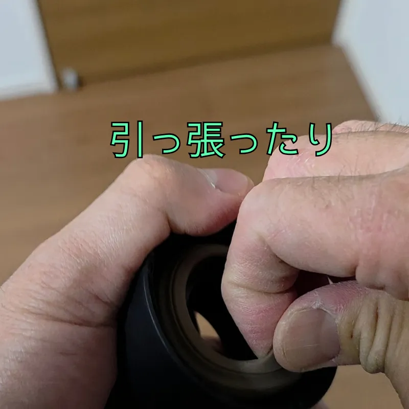 パッキンを引っ張り、嵌めこむ様子。