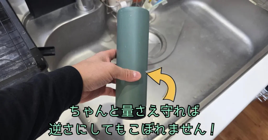 逆さまにした水筒を持っている手元の写真。