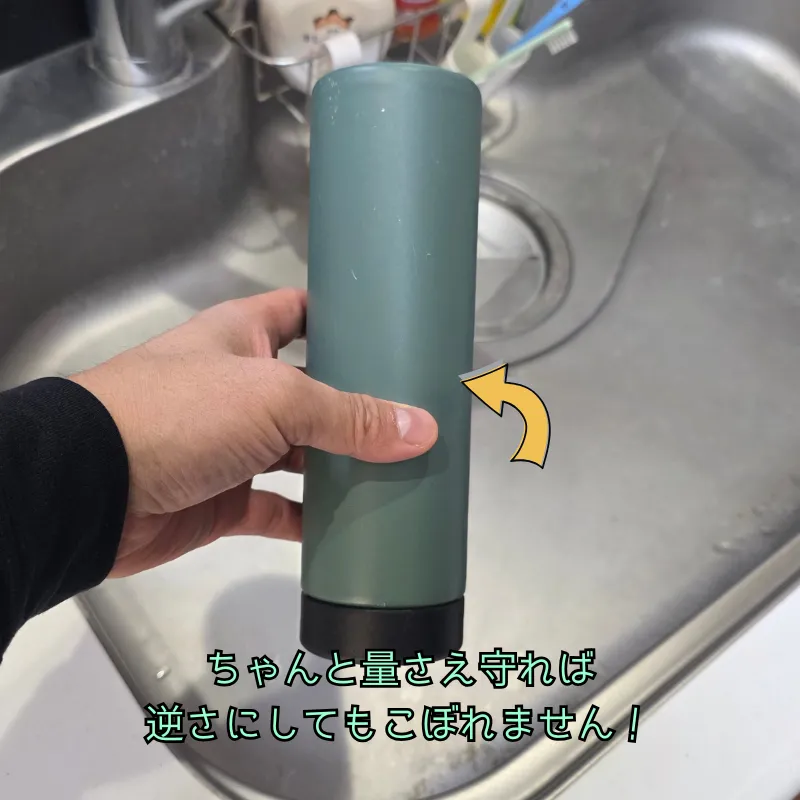 逆さまにした水筒を持っている手元の写真。
