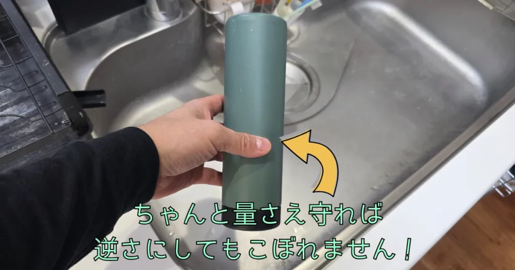 逆さまにした水筒を持っている手元の写真。