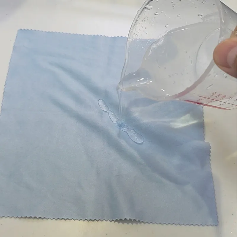 作った重曹水を広げた布に適量垂らしている場面。