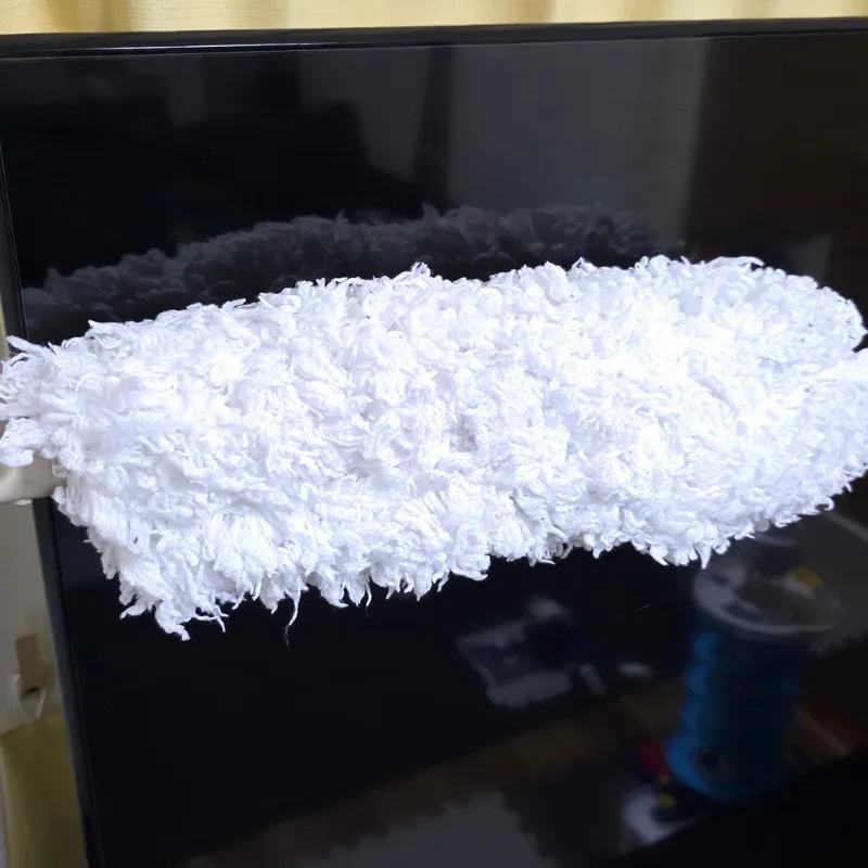 テレビ画面の表面のホコリをハンディモップで優しく払い落としている様子。