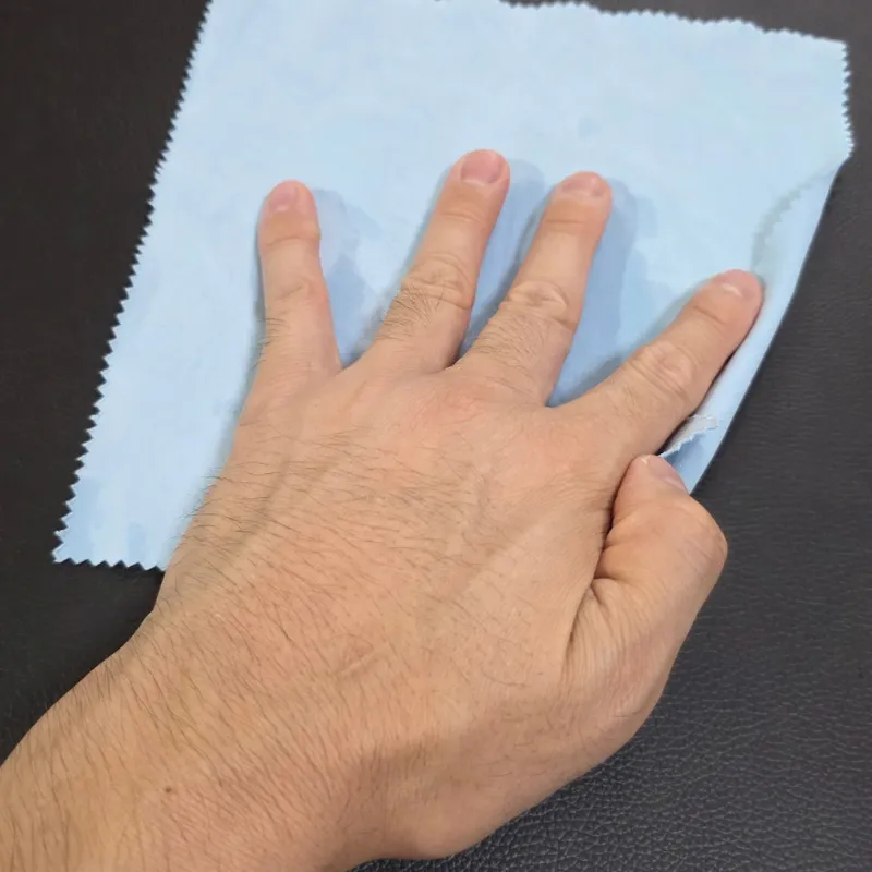クリーナーをつけたクロスの上に手のひら全体を添えて合皮を優しく拭いている状態。