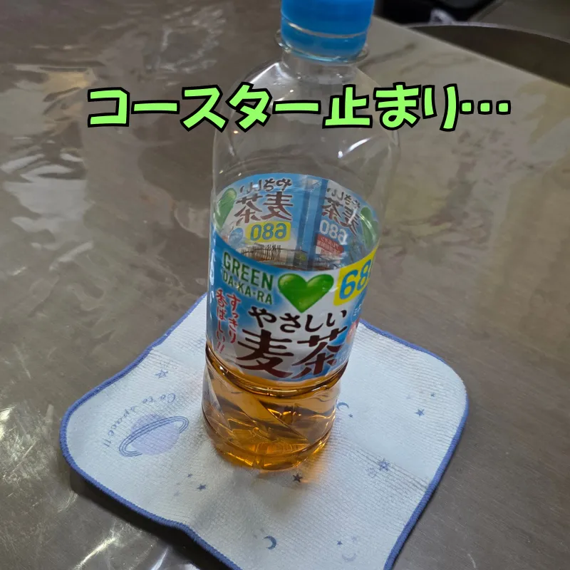 水色のハンカチの上に冷たい麦茶のペットボトルを置いてコースター代わりにしている状態。