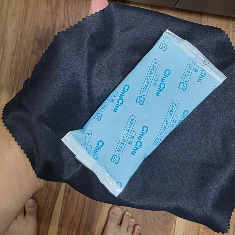 手のひらに広げた黒い布の上に青い保冷剤を乗せている状態。