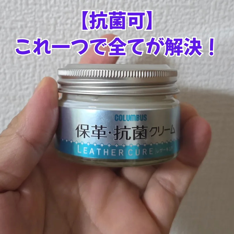 財布の日常ケアにおいて保湿からツヤ出し、カビ予防まで1つで完結する、手で持たれたコロンブスのレザーキュア保革・抗菌クリームの瓶。