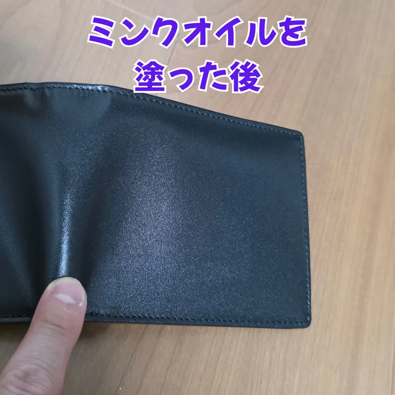 ミンクオイルを塗布した後の、革の繊維の奥から重厚なツヤが生まれている黒い革財布。