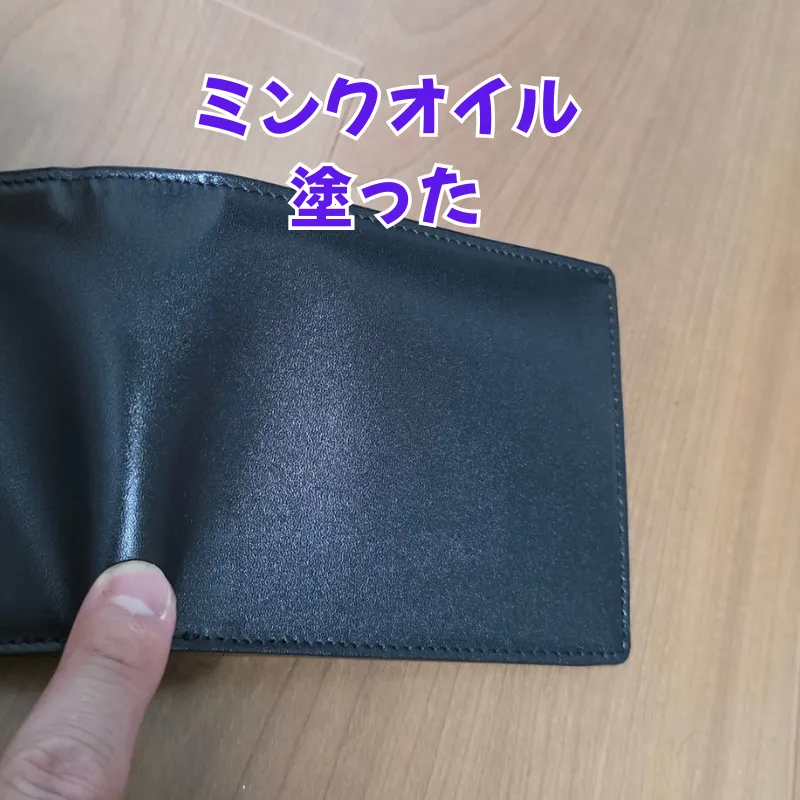 ミンクオイルを塗布した後の、革の繊維の奥から重厚なツヤが生まれている黒い革財布。