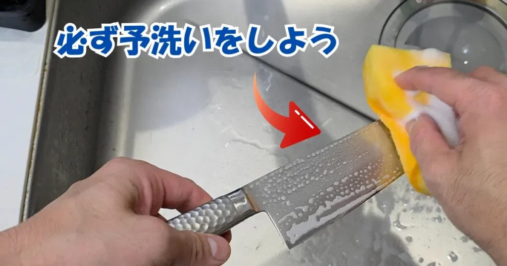 シンクで包丁を泡のついたスポンジで手洗いしている様子。