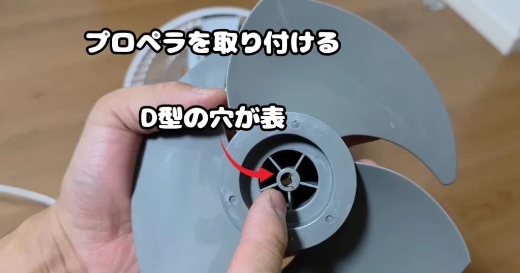 モーター軸に正しく差し込むため、プロペラ中央にあるD型の穴が表側に向いているかを確認している様子。