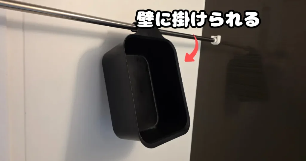使用後に水気を切りながら保管できるよう、側面のフックを利用して浴室のポールに吊り下げて収納されている黒いバケツ。