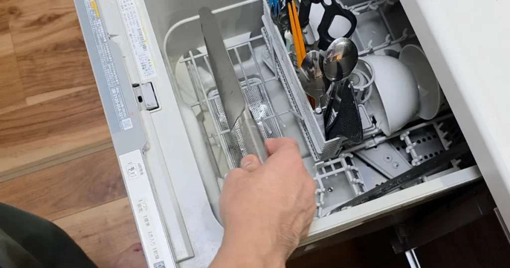 引き出し式の食洗機に包丁を入れている様子。