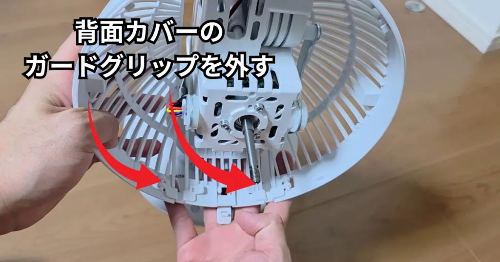 後面カバーの下部についているガードグリップを横にスライドさせ、モーター本体からカバーを完全に取り外している様子。
