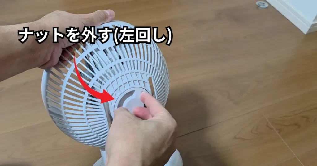 後面カバーを固定している中央のナットを、通常のネジと同じ左回しで取り外している様子。