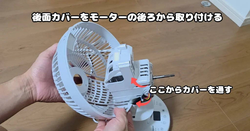 洗浄して乾燥させた後面カバーを、モーター本体の後ろ側から通して取り付けている様子。