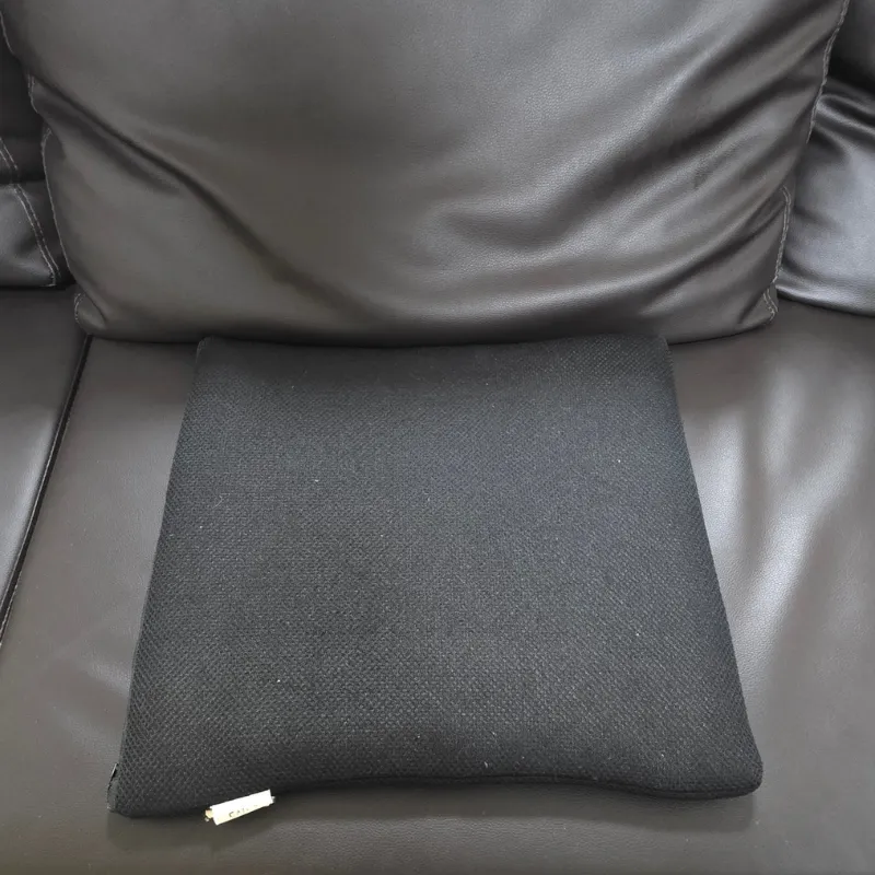 黒いカウチソファの座面に敷かれた黒いスクエアクッション。