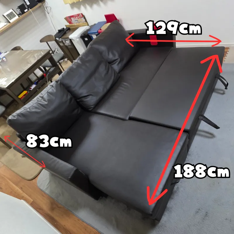 ベッド展開時のサイズが幅129cm、奥行188cmとなる黒いカウチソファ。