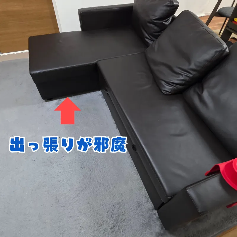 黒いカウチソファのL字部分が手前に大きく出っ張っている様子。