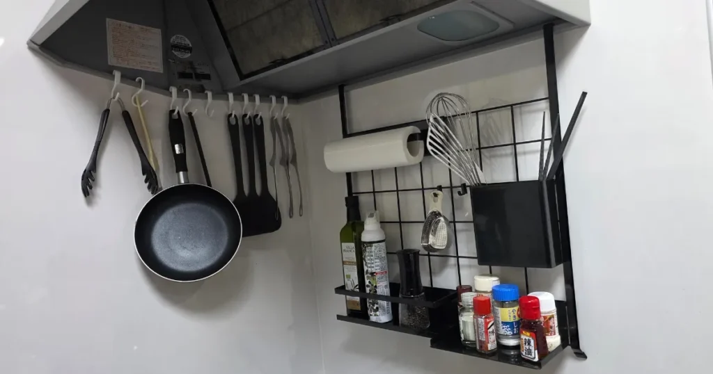 山崎実業(tower)のレンジフードメッシュパネルを活用したコンロ周りの収納風景。