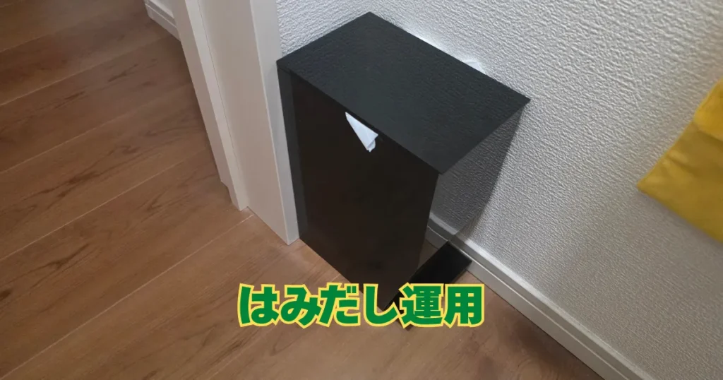黒いtowerのサニタリーボックスのフタから、セットしたレジ袋の端がはみ出している状態。