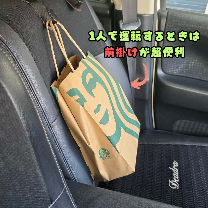 1人での運転時に便利な、助手席側に回した車のヘッドレストフックに、スターバックスの紙袋が掛けられている。