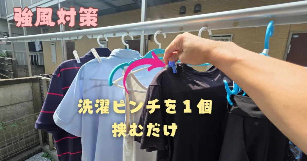 ハンガーに掛けた黒いTシャツの肩口を、洗濯バサミ1つで留めている様子。