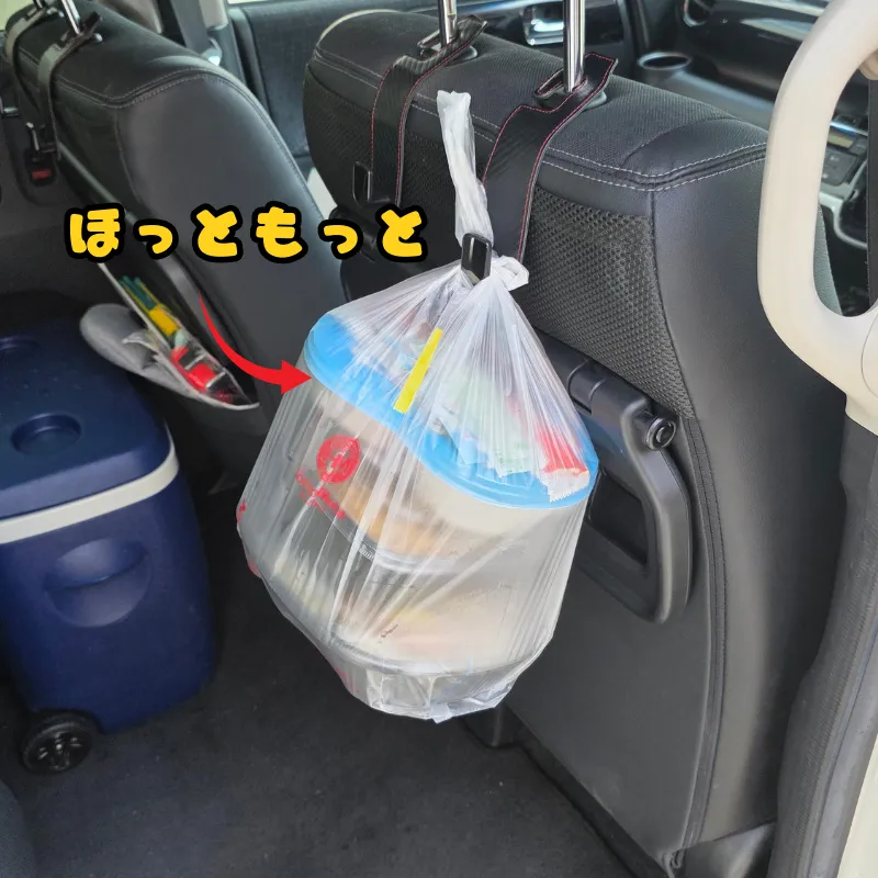 車のヘッドレストフックに、ほっともっとの弁当が入ったレジ袋が掛けられている。