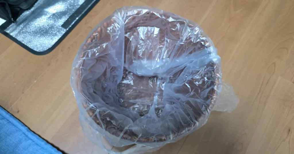 口径約25.5cm・高さ約24cmのリビング用ゴミ箱に、スーパーの標準的なレジ袋がインナーとしてジャストフィットしている状態。
