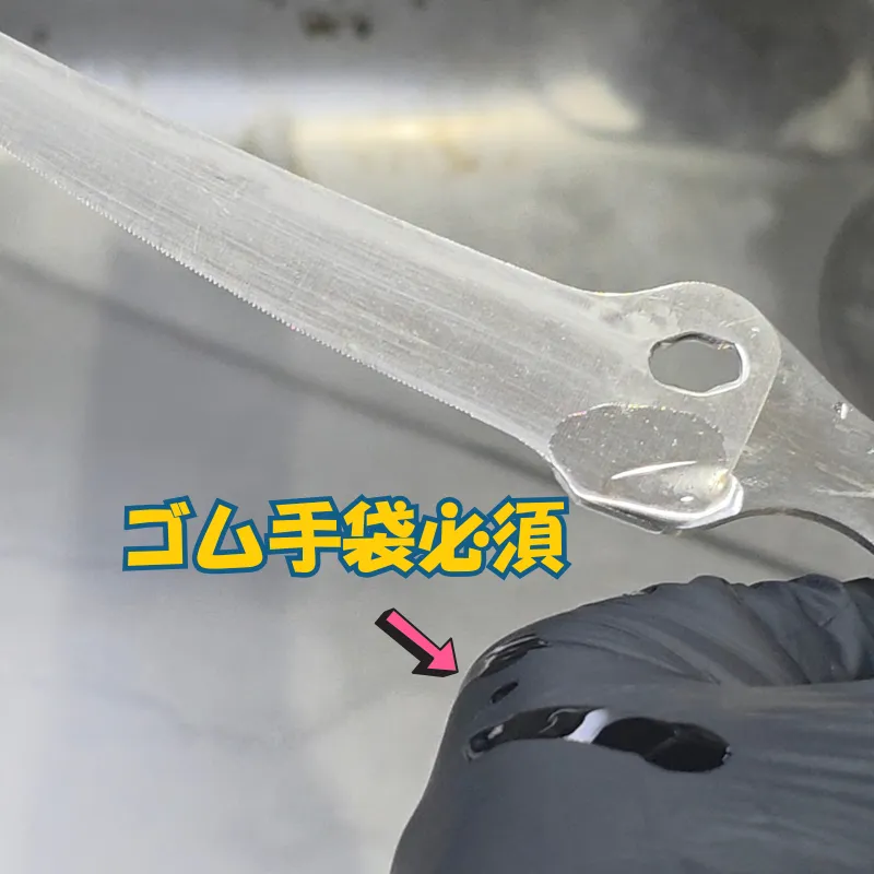 細かい結合部にサビ取り剤を塗布する際、着用している黒いゴム手袋に液がこぼれ落ちている様子。