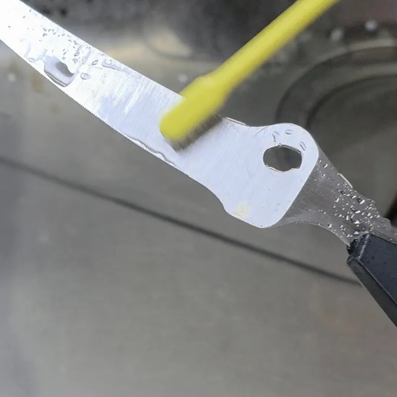 キッチンバサミに塗った重曹ペーストを歯ブラシでこすっている様子。