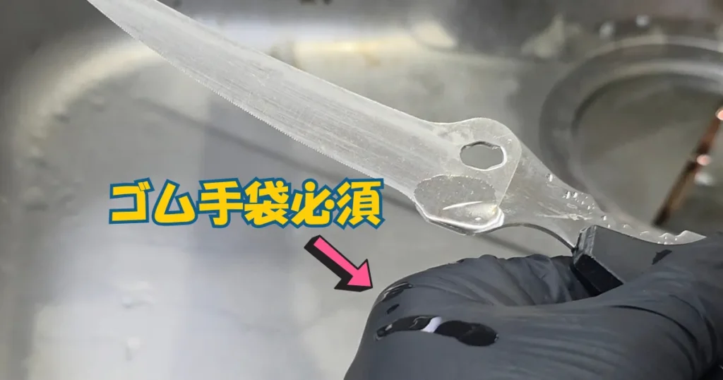 細かい結合部にサビ取り剤を塗布する際、着用している黒いゴム手袋に液がこぼれ落ちている様子。