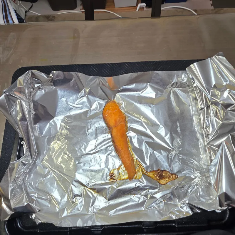 アルミホイルの上に直接置いて焼き上がった鮭の切り身と、逃げ場がなく周りに溜まってしまった水分や脂。