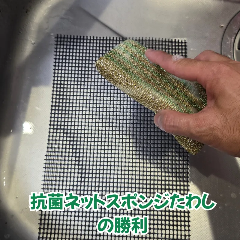 シンク内でグリルマットをアルミ蒸着ネットで洗っている様子。